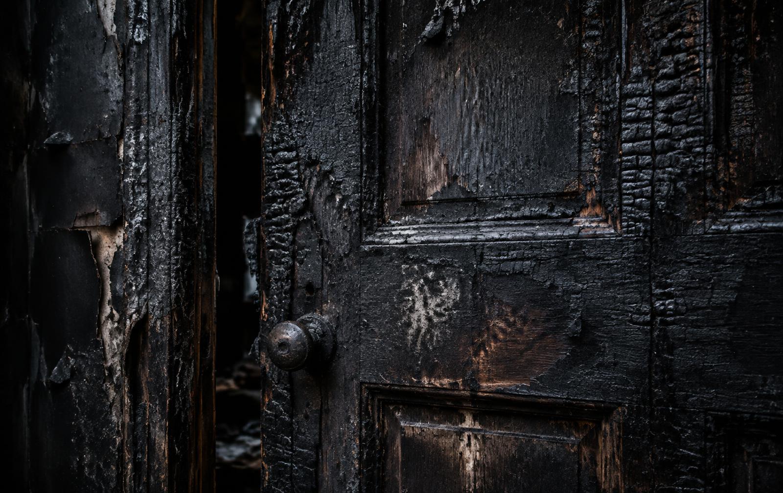 Houten deur met verkoold hout na brandschade