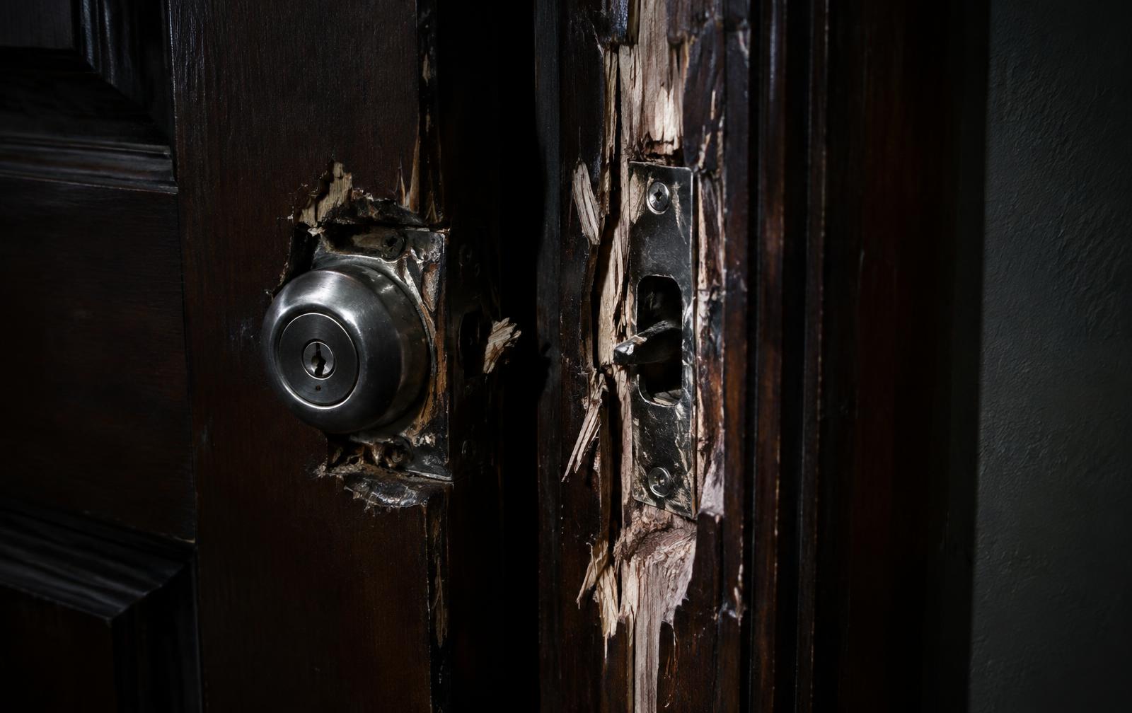 Beschadigd houten deurkozijn met een opengebroken slot na inbraak